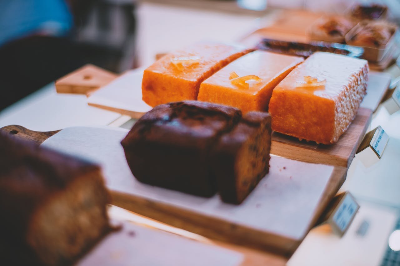 Variety of delicious pastries displayed on a wooden board in a bakery shop.